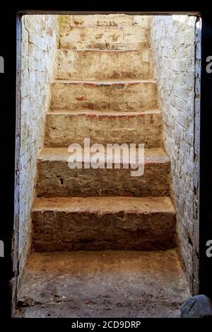 Alte einstürzende Steintreppe, die aus dem Keller führt. Stockfoto