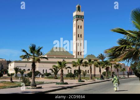 Marokko, Westsahara, Dakhla, Frau in traditioneller saharauischer Kleidung beim Spaziergang vor der Eddarham Moschee Stockfoto
