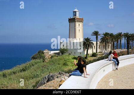 Marokko, Tangier Tetouan Region, Tangier, marokkanische Touristen sitzen vor dem Leuchtturm von Cape Spartel mit Blick auf das Mittelmeer Stockfoto