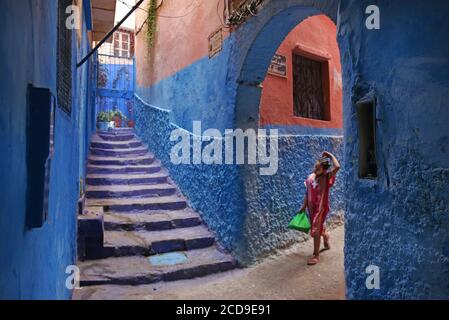 Marokko, Tangier Tetouan Region, Tangier, marokkanisches Mädchen in einer Gasse der Medina mit blauen Wänden Stockfoto