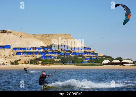 Marokko, Westsahara, Dakhla, Kitesurfer auf der Lagune mit Drachencamp Dakhla Attitude im Hintergrund Stockfoto