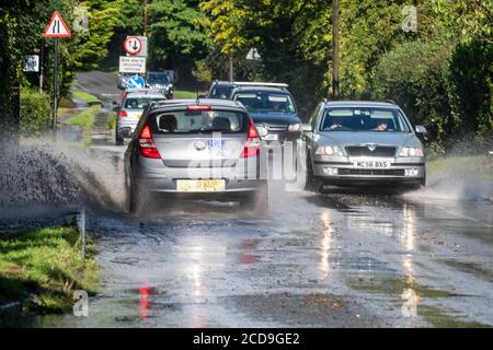 Wetter: Starker Regen durch Gewitter. Verkehrsverlangsamung wegen Hochwasser auf der Straße. Godshill, New Forest, Hampshire, England, Vereinigtes Königreich, August 2020, Stockfoto