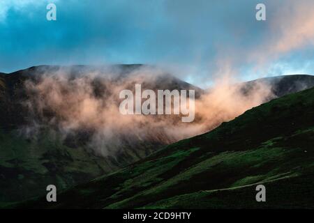 Sonnenaufgang leuchtet am frühen Morgen Nebel zwischen trostlosen Rigg und Knott Rigg am Newlands Pass, Lake District, Cumbria, England, Großbritannien Stockfoto