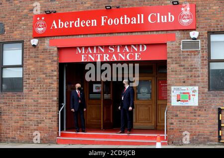 Mitarbeiter tragen vor Beginn des ersten Qualifikationsspiel der UEFA Europa League im Pittodrie Stadium, Aberdeen, Schutzmasken vor dem Haupttribüneneingang des Stadions. Stockfoto