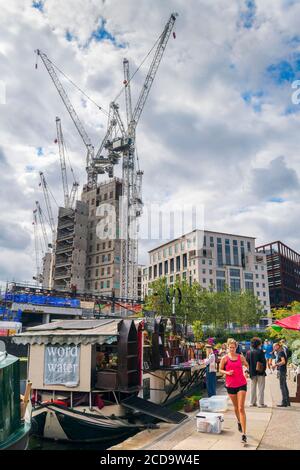 Ein Läufer kommt an der schwimmenden Buchhandlung "Word on the Water" vorbei, die auf einem Kanalkahn am King's Cross in der Nähe von Islington im Norden Londons basiert. Stockfoto