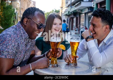 Multirassische Gruppe von Freunden trinken und lachen auf der Straßenterrasse des Cafés. Freundschaftskonzept mit jungen multiethnischen Menschen genießen Zeit toge Stockfoto