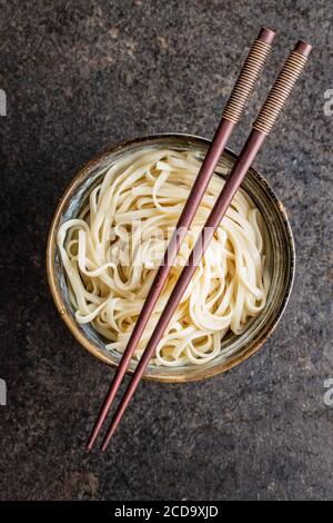 Gekochte udon-Nudeln. Traditionelle japanische Nudeln in Schale auf schwarzem Tisch. Stockfoto