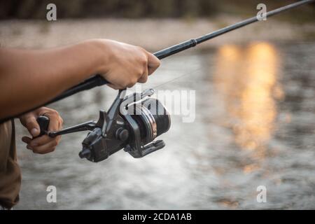 Shallow Focus Aufnahme eines Fischers, der eine Angelrute hält Stockfoto