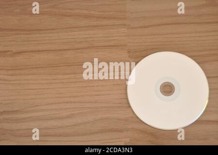Weiße DVD-Disc auf Holzhintergrund leere DVD für die Aufnahme Filme und Daten Stockfoto