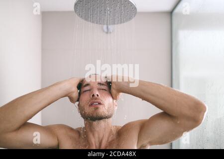 Der Mann in der Dusche nahm ein heißes Bad und waschte Haare und Körper im luxuriösen Hotelbadezimmer. Entspannende Hautpflege Männer Schönheit Stockfoto