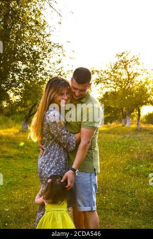 Glückliche Familie genießen im Park. Niedliche Porträt von glücklichen Familie. Eltern mit kleiner Tochter. Lifestyle Familie Liebe zuerst. Stockfoto