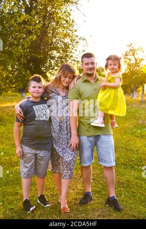 Glückliche Familie genießen im Park. Niedliche Porträt von glücklichen Familie. Eltern mit Vorschulsohn und kleiner Tochter. Lifestyle Familie Liebe zuerst. Stockfoto