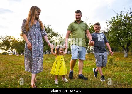 Glückliche Familie genießen im Park. Niedliche Porträt von glücklichen Familie. Eltern mit Vorschulsohn und kleiner Tochter. Lifestyle Familie Liebe zuerst. Stockfoto