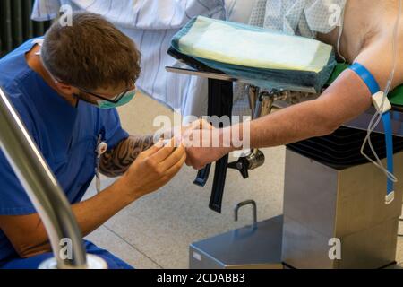 Eine Venenkanüle wird in einen Patienten in einem gelegt Operationssaal Stockfoto