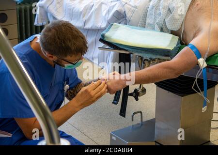 Eine Venenkanüle wird in einen Patienten in einem gelegt Operationssaal Stockfoto