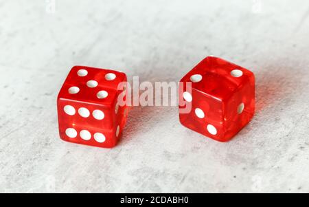 Zwei durchscheinende rote Würfelwürfelwürfelchen auf weißem Brett, das Natur zeigt Oder Seven Out (Nummer 5 und 2) Stockfoto