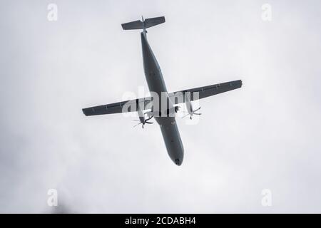 Ein großes Propellerflugzeug mit verlängertem Fahrwerk fliegt hinein Der Himmel Stockfoto