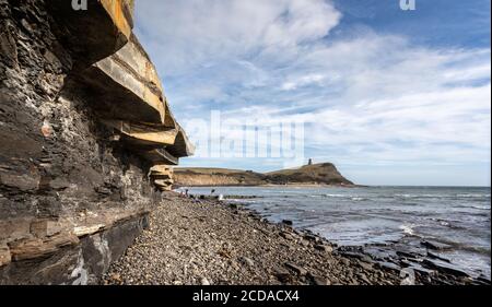 Kimmeridge Bay mit felsiger Uferlinie und Schiefer- und Kalksteinklippen mit dem Clavell Tower im Hintergrund in Kimmeridge, Isle of Purbeck, Dorset, U Stockfoto