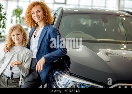 Portrait von glücklichen kaukasischen Besitzer von Neuwagen. Familie bekommen ihr neues Auto, ihre Träume wahr wurden. In Händler Stockfoto