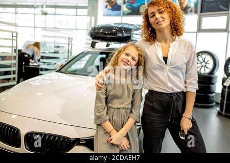 Glückliche kaukasische Familie jetzt die Besitzer von neuen repräsentativen Auto. Familie machte Kauf in Händler, genießen Sie mit neuen Automobil Stockfoto