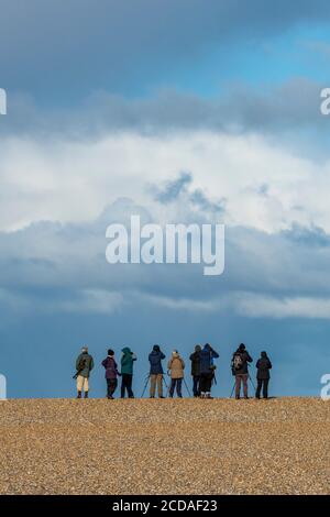 Eine Gruppe von Vogelbeobachtern oder Vogelgezwitscher gegen einen blauen Himmel am Strand von snettisham im Norden von norfolk. Stockfoto