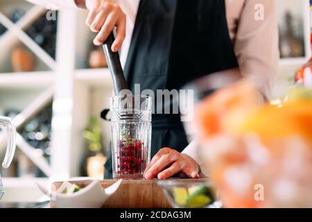 Der Barkeeper bereitet auf der Terrasse des Restaurants einen Beerencocktail zu. Stockfoto