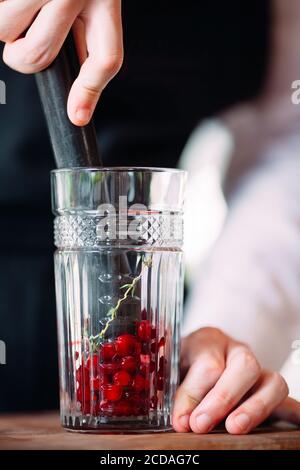 Der Barkeeper bereitet auf der Terrasse des Restaurants einen Beerencocktail zu. Stockfoto