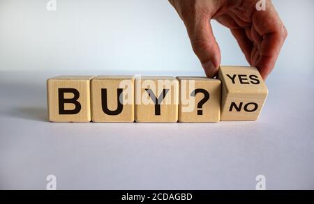 Zeit zum Kauf. Hand dreht einen Würfel und ändert das Wort 'Nein' in 'Ja'. Schöner weißer Hintergrund. Geschäftskonzept. Speicherplatz kopieren. Stockfoto