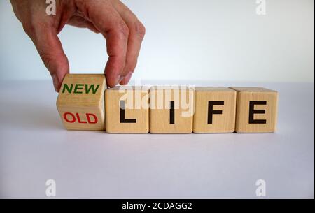 Hand dreht einen Würfel und ändert die Worte "altes Leben" in "neues Leben". Schöner weißer Hintergrund. Geschäftskonzept, Kopierbereich. Stockfoto