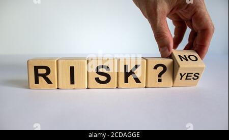 Hand dreht einen Würfel und ändert das Wort 'Nein' in 'Ja'. Wort „Risiko“. Schöner weißer Hintergrund. Geschäftskonzept. Speicherplatz kopieren. Stockfoto