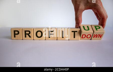 Hand dreht Würfel und ändert den Ausdruck "Profit down" in "Profit up". Schöner weißer Hintergrund. Geschäftskonzept, Kopierbereich. Stockfoto