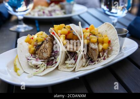 Fisch mit Ananas und Tacos auf dem Teller Stockfoto