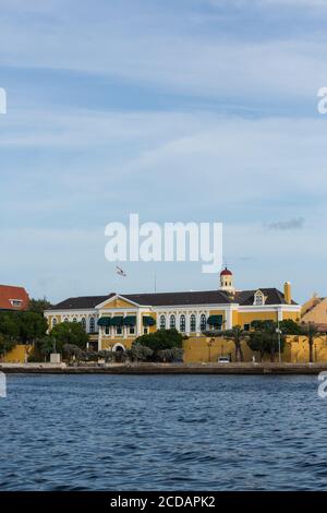 Die Vorderseite des Gouverneurspalastes in Fort Amsterdam mit dem Turm der Fort Church dahinter. Das Hotel liegt im Bezirk Punda von Willemstad, der Hauptstadt der t Stockfoto