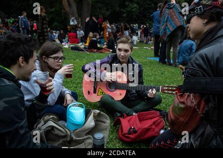 Moskau, Russland. 27. August 2020 Jugendliche singen ein Lied während der "Mad Tea Party" im Zarizyno Park in Moskau, Russland. Die "Mad Tea Party" ist eine inoffizielle Jugendparty, bei der die Menschen in ungewöhnlichen Kostümen Tee trinken, tanzen, singen und Spaß haben Stockfoto