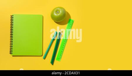 Helle Schulbedarf, Notizbücher auf gelbem Hintergrund. Draufsicht. Speicherplatz kopieren. Stockfoto