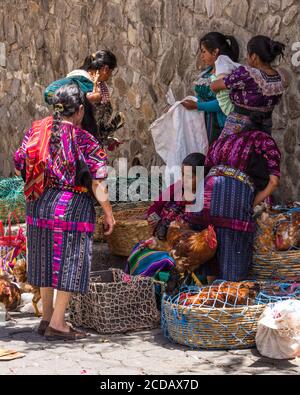 Quiche Maya Frauen verkaufen lebendes Geflügel auf dem Outdoor-Markt in Chichicastenango, Guatemala. Eine Frau hält einen Beutel offen, in den sie das Huhn legen kann Stockfoto