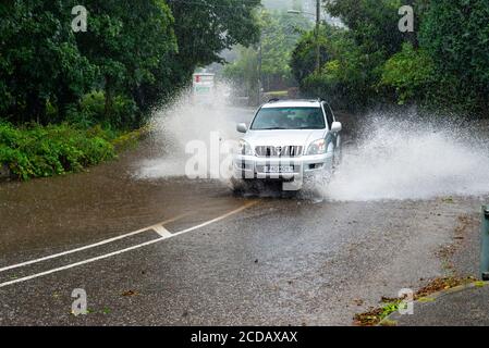 Par, Cornwall, 27/08/2020. Autos sprühen riesige Sprays auf, während sie nach heftigen Regenfällen durch die überfluteten Straßen in Cornwall kämpfen. Stockfoto