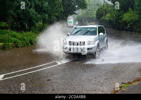 Par, Cornwall, 27/08/2020. Autos sprühen riesige Sprays auf, während sie nach heftigen Regenfällen durch die überfluteten Straßen in Cornwall kämpfen. Stockfoto