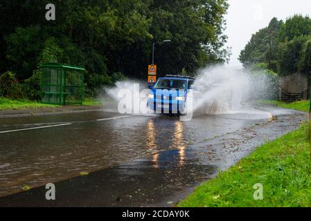 Par, Cornwall, 27/08/2020. Autos sprühen riesige Sprays auf, während sie nach heftigen Regenfällen durch die überfluteten Straßen in Cornwall kämpfen. Stockfoto