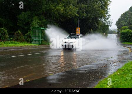 Par, Cornwall, 27/08/2020. Autos sprühen riesige Sprays auf, während sie nach heftigen Regenfällen durch die überfluteten Straßen in Cornwall kämpfen. Stockfoto