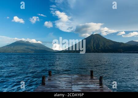 Atitlan See mit San Pedro Vulkan in der rechten Mitte und die Doppelgipfel des Toliman Vulkan auf der linken Seite. Der Gipfel des Vulkans Atitlan liegt hinter Toliman an Stockfoto