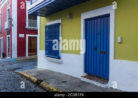 Bunt bemalte Häuser in einer engen Kopfsteinpflasterstraße in der historischen Kolonialstadt Old San Juan, Puerto Rico. Stockfoto