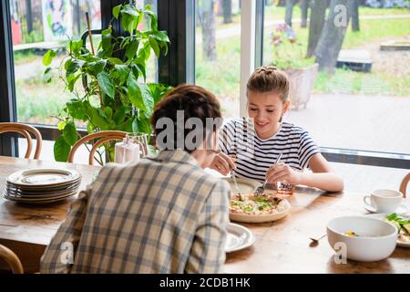 Mutter und Tochter teilen sich Pizza in einem Café. Stockfoto