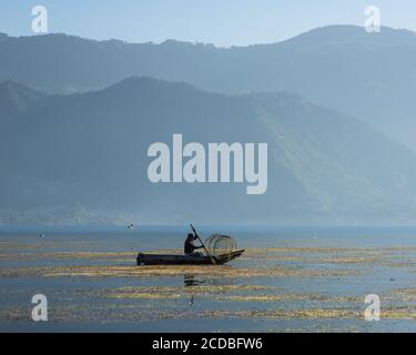 Ein Maya-Fischer mit seiner Drahtfalle in seinem Cayuco oder Kanu auf dem Atitlan-See bei San Pedro la Laguna, Guatemala. Stockfoto