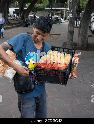 Ein junger Mann verkauft Snacks in einem Park in Oaxaca, Mexiko. Stockfoto