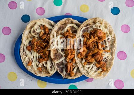 Memelas oder Memelitas sind gebratene oder geröstete Kuchen aus masa Maismehl und garniert mit gebratenen Bohnen und verschiedene Frische Zutaten wie Queso Fr. Stockfoto