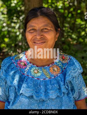 Eine Tzutujil Maya Frau mittleren Alters in traditioneller Kleidung posiert für ein Bild in San Pablo la Laguna, Guatemala. Stockfoto