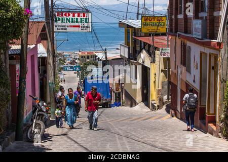 Eine Tzutujil Maya Familie geht einen steilen Hügel hinauf in San Pedro la Laguna am Ufer des Atitlan Sees in Guatemala. Die meisten Frauen und Mädchen noch wir Stockfoto