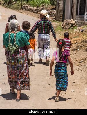 Drei Generationen einer Tzutujil Maya-Familie in traditioneller Kleidung Charakteristisch für San Pedro la Laguna Wandern auf einem Schmutz Straße am Ufer des Sees Stockfoto