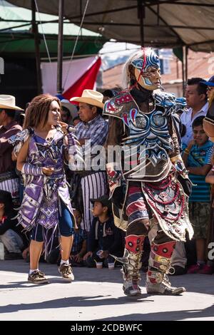 Kostümierte Tänzer in Masken treten für das Festival von Santiago auf dem offenen Markt in Santiago Atitlan, Guatemala. In Santiago Atitlan, Guatemala. Stockfoto